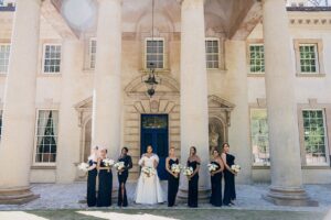 Bride and Bridesmaids posing in front of the Columns side of the Swan House