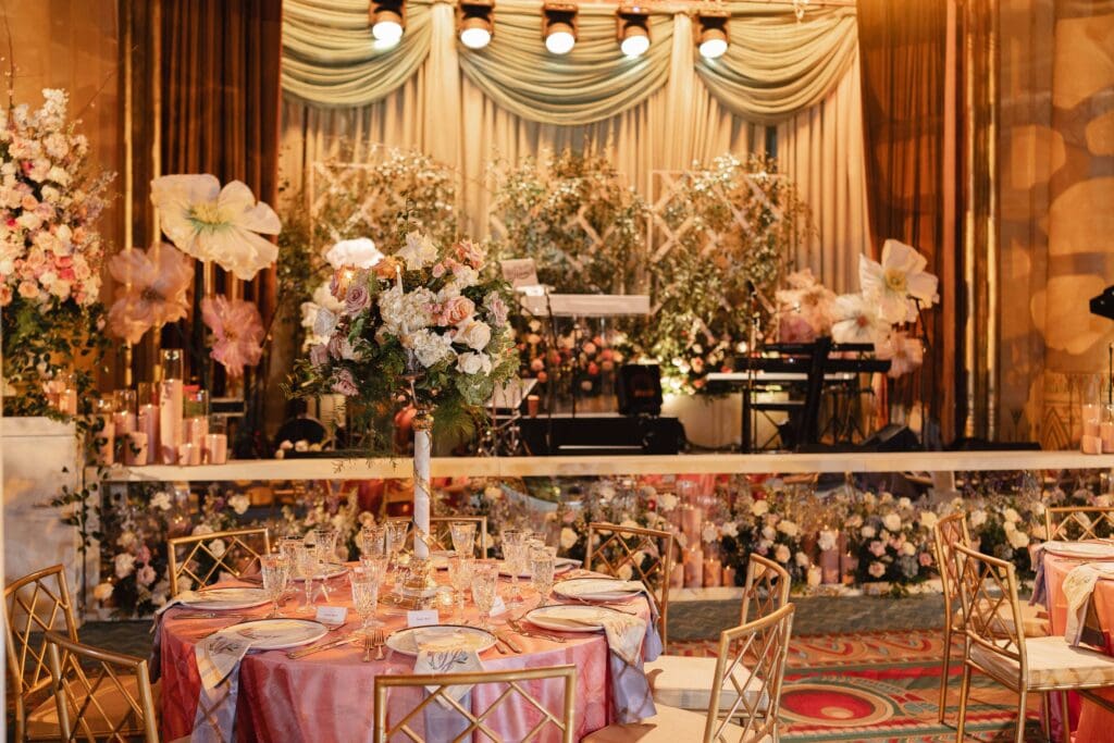 Fox Theatre Atlanta, GA Stage with cascading sage drape with jumbo faux florals and natural floral meadows embedded at the front of the stage.